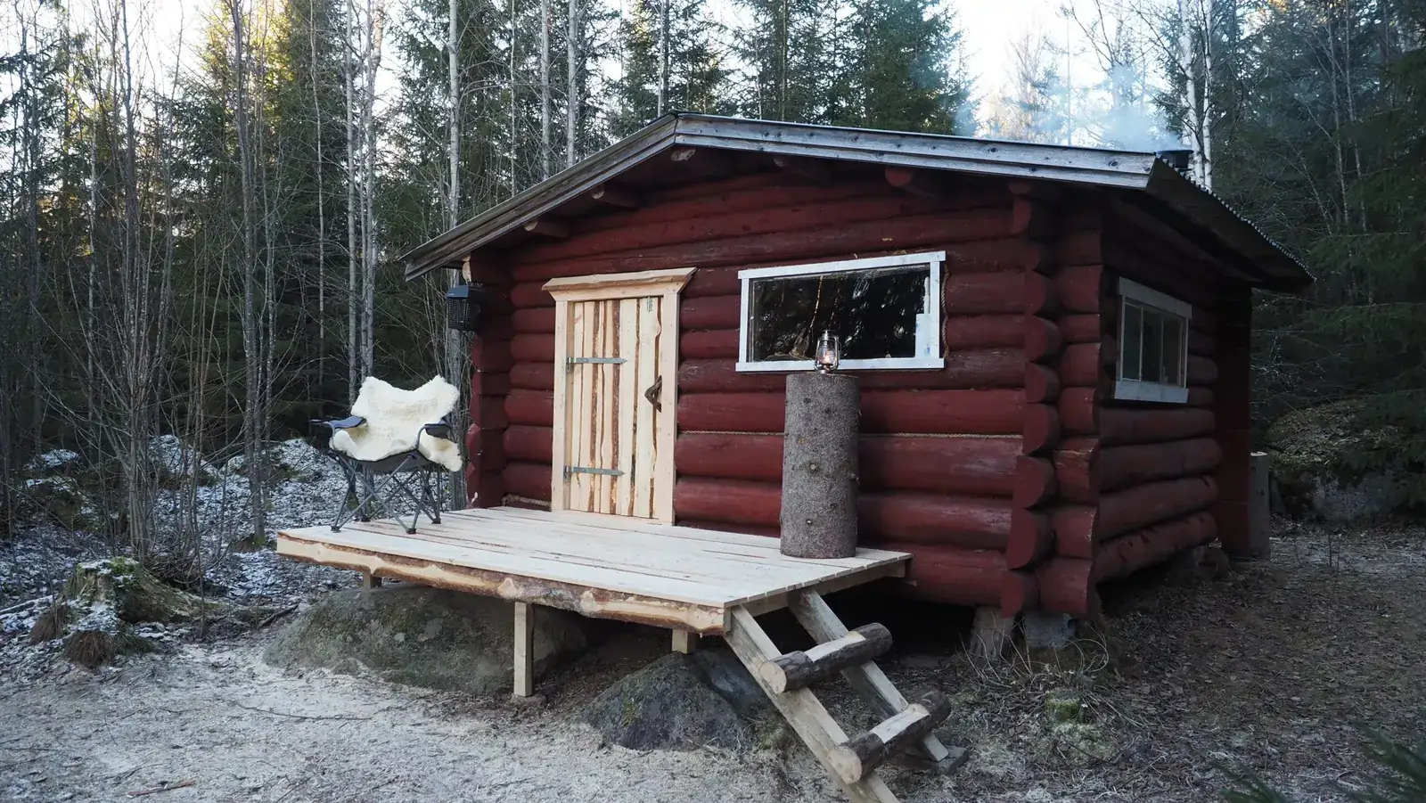 The forest cabin with its porch in the woods of Dalarna