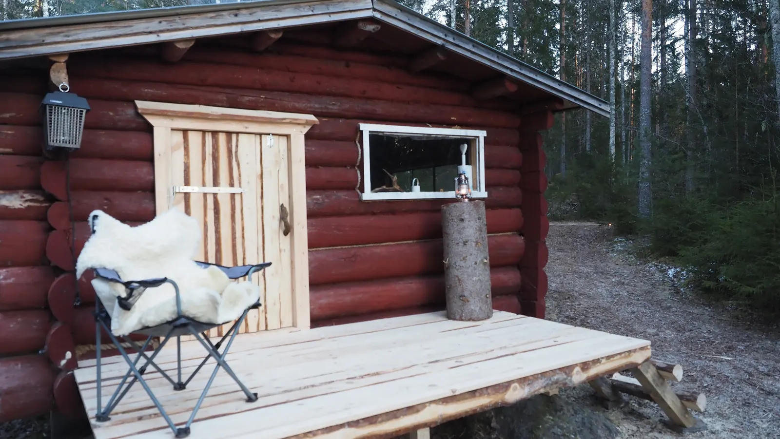 The log cabin with its porch in the forest