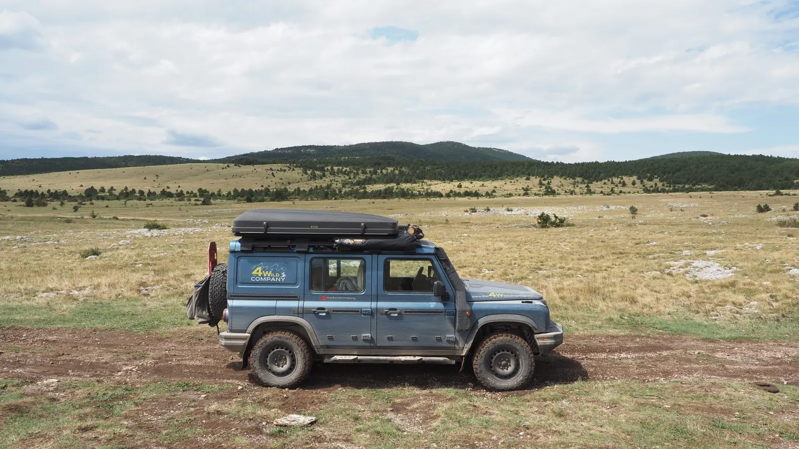 Ineos Grenadier with rooftop tent on a mountain plateau