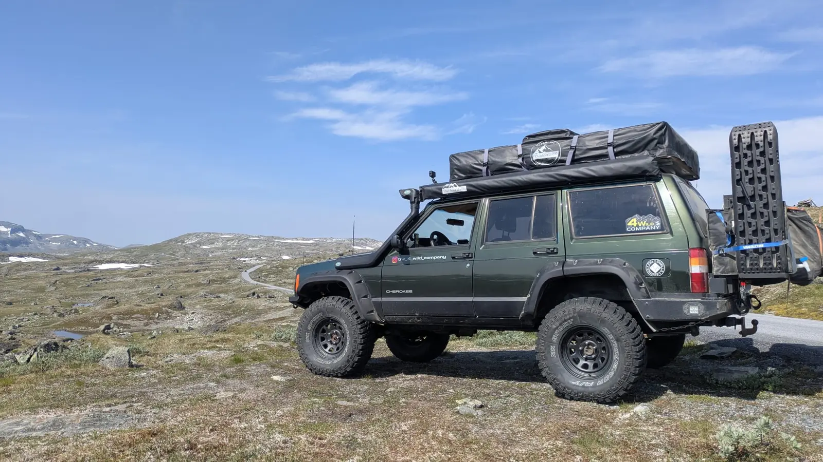 Jeep Cherokee XJ with rooftop tent on a Norwegian mountain plateau