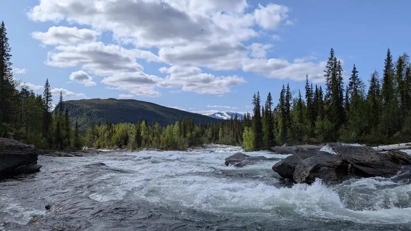 River rapids near Kvikkjokk with mountains behind