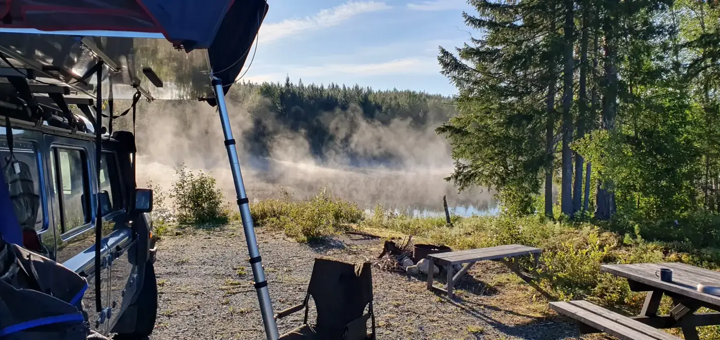 Morning mist over the lake at a forest camp