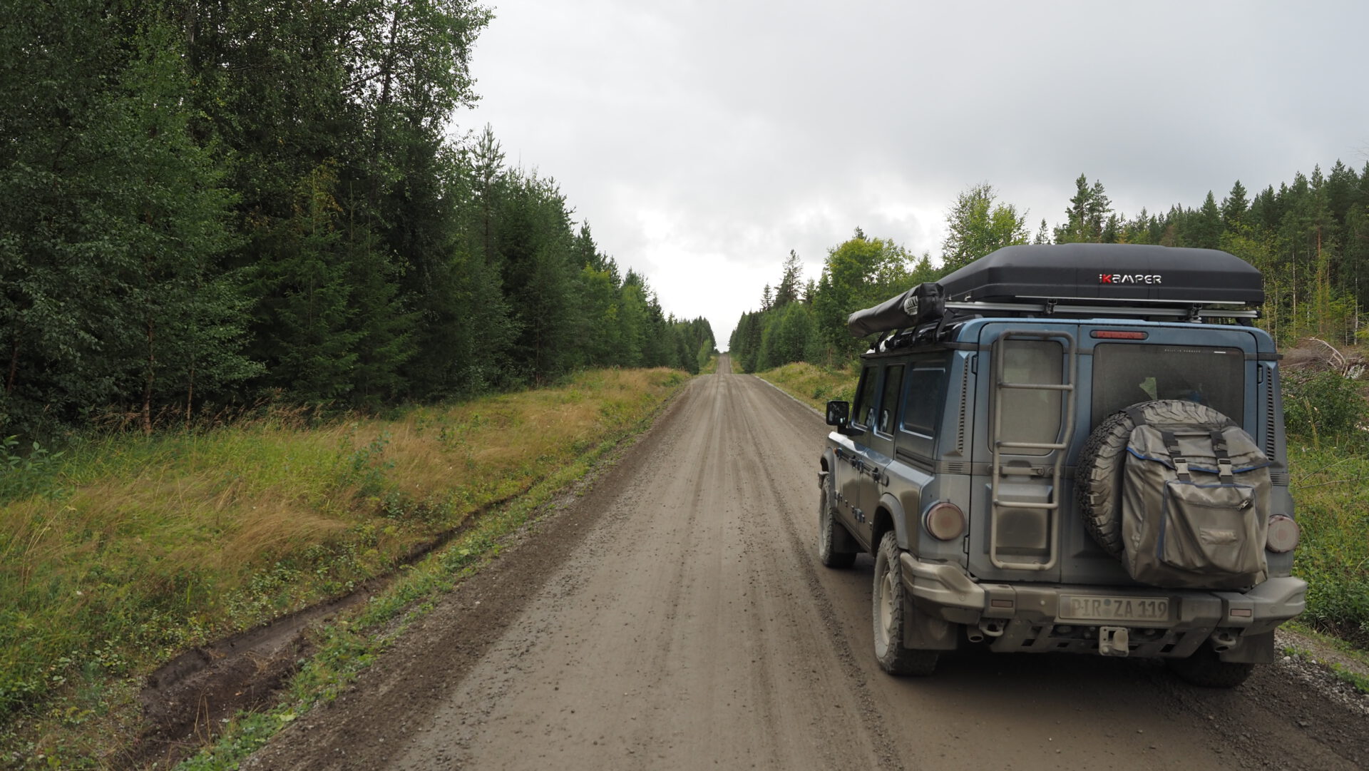 Grenadier jeep 4x4 with ikamper rooftop tent driving on a dirt road in Sweden