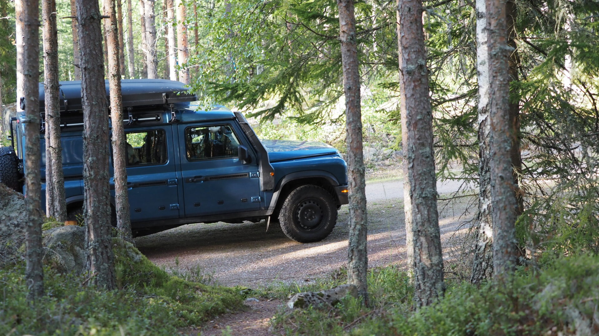 Grenadier jeep 4x4 with ikamper rooftop tent driving through a Swedish forrest